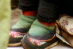 China - Kunming - Old lady with small feet. The ancient custom of tying the feet of young girls was prohibited after the revolution. One can still see a few old women who have gone through this terrible ordeal