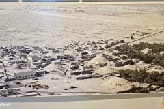 Bahrain - Manama - Bahrain National Museum - Aerial view of A'ali town and its burial mounds. One of the large mound fields south of A'ali is in the background with Hamad Town at the back. The Grand Mosque of A'ali is in the front left. This photo was taken some decades ago.