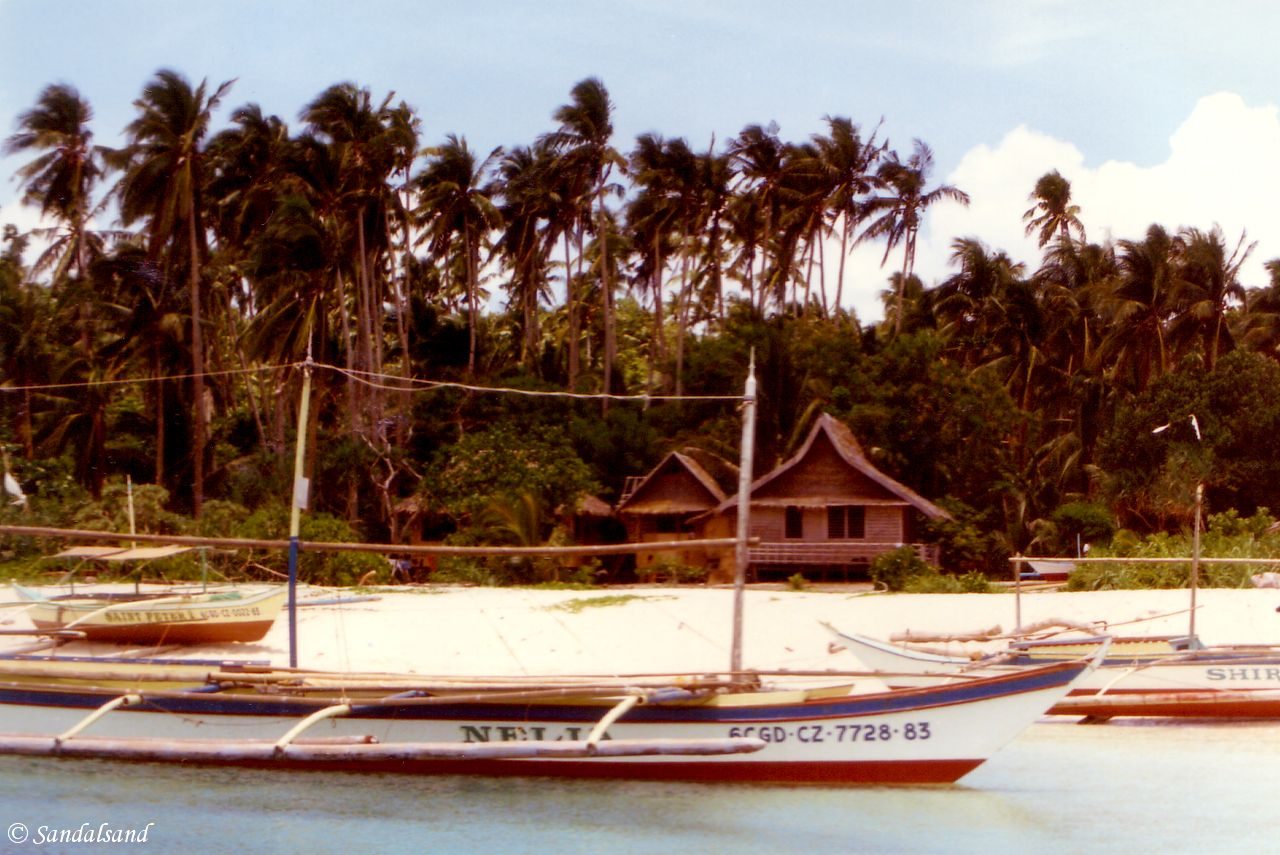 Philippines - Boracay - "Banca" outrigger canoes on beach with bungalow cabins behind